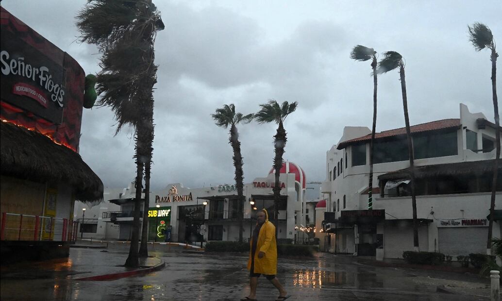 Un hombre cruza la calle ante la llegada de "Hilary" en Cabo San Lucas, Baja California. Foto: AFP