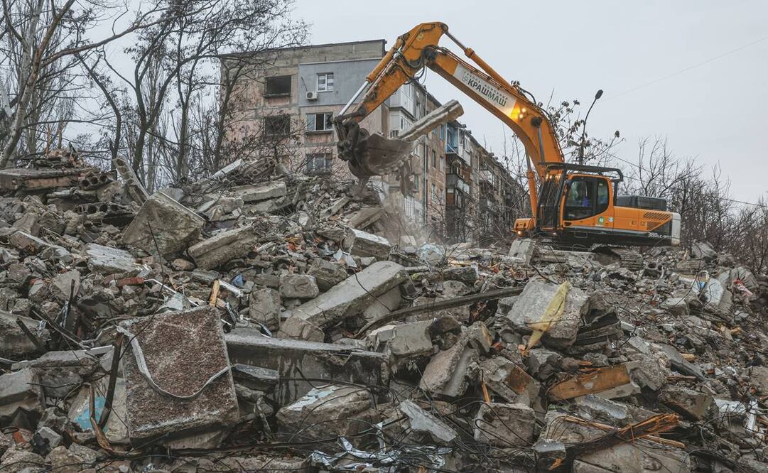 Una excavadora limpia los escombros de un edificio destruido por las fuerzas rusas en la localidad de Mariupol.
