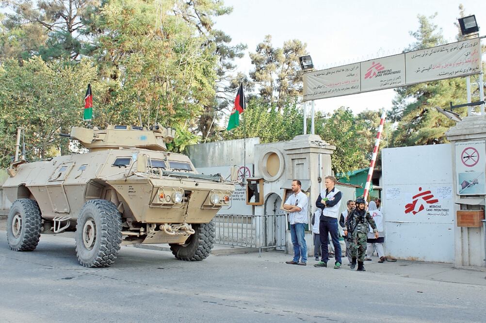 Christopher Stokes (segundo de izq. a der.), director general de Médicos Sin Fronteras, mira un tanque afgano afuera del hospital atacado en Kunduz (NAJIM RAHIM. AP)