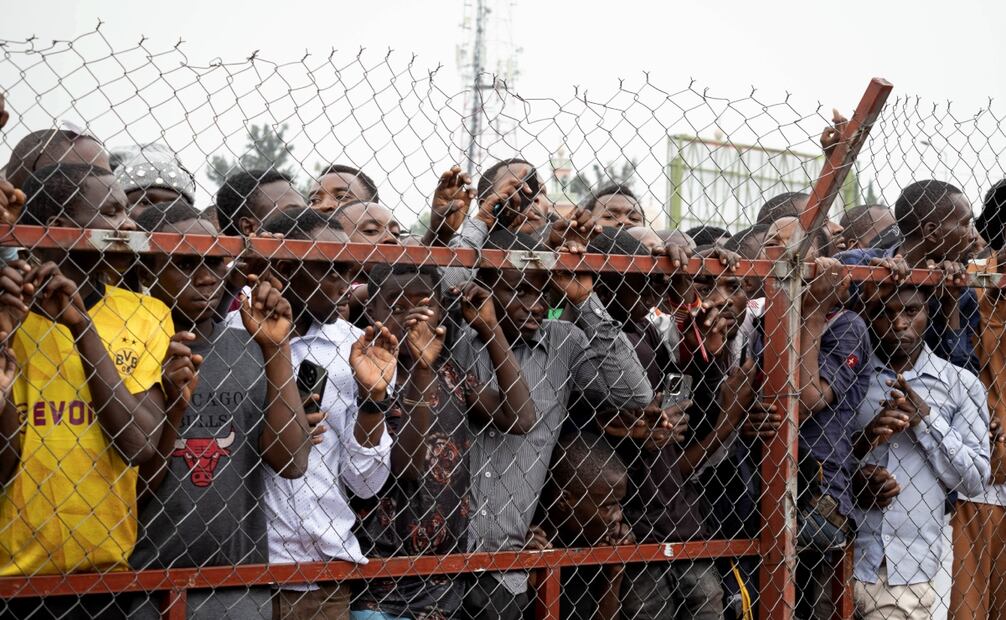 Los residentes de la ciudad se reúnen detrás de una valla para asistir a una reunión convocada por el grupo rebelde M23 en Goma. Foto: EFE