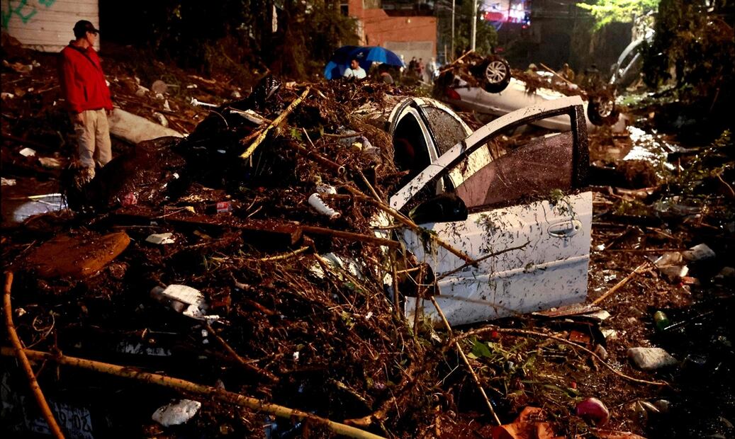 Un hombre observa los autos arrastrados por las inundaciones repentinas causadas por las fuertes lluvias en Zapopan, Jalisco, el 15 de julio de 2025. Foto: AFP