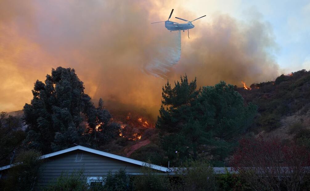Elementos de seguridad hacen esfuerzos para apagar el incendio. Foto: EFE