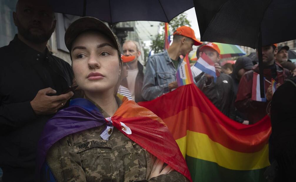 Una soldado, envuelta en una bandera LGBT, participa en la marcha del orgullo gay en Kiev, Ucrania. Foto:AP