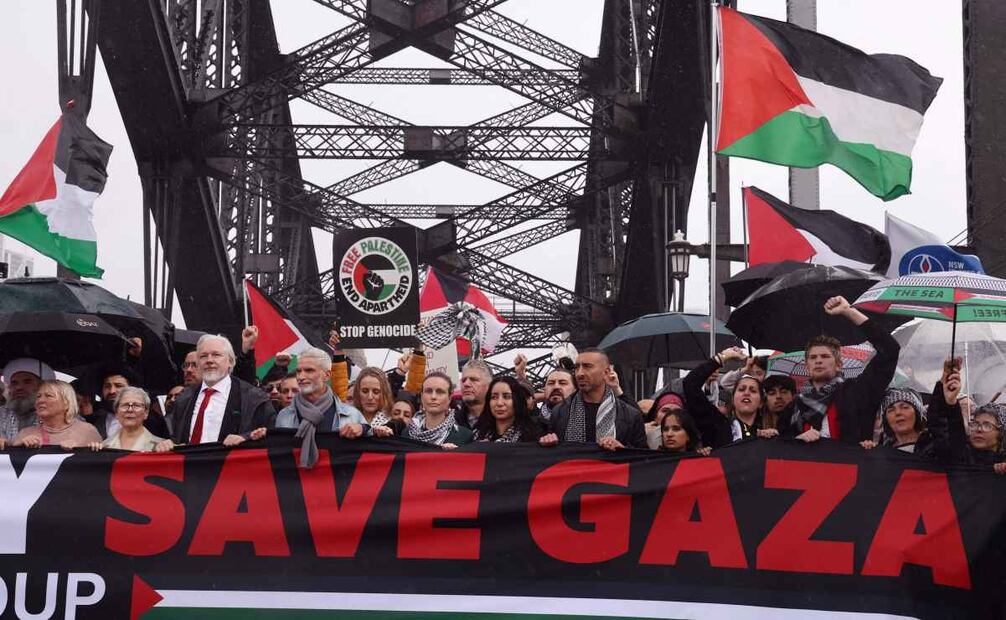 Manifestantes, entre ellos el fundador de WikiLeaks, Julian Assange (tercero por la izquierda, con corbata roja), marchan por el Puente del Puerto de Sídney durante una manifestación pro palestina contra las acciones de Israel y la escasez de alimentos en la Franja de Gaza, en Sídney el 3 de agosto de 2025. Foto: AFP