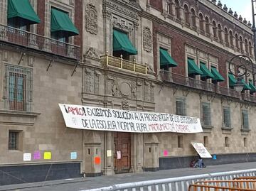 Normalistas de Chiapas saltan vallas metálicas de Palacio Nacional y colocan manta abajo del Balcón Presidencial
