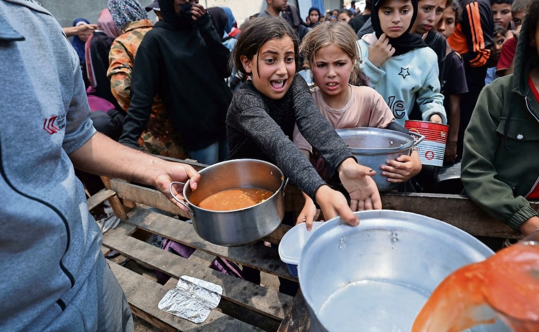 Niños palestinos en un punto de distribución de comida en Nuseirat, en el centro de la Franja de Gaza. Foto: Eyad Baba / AFP
