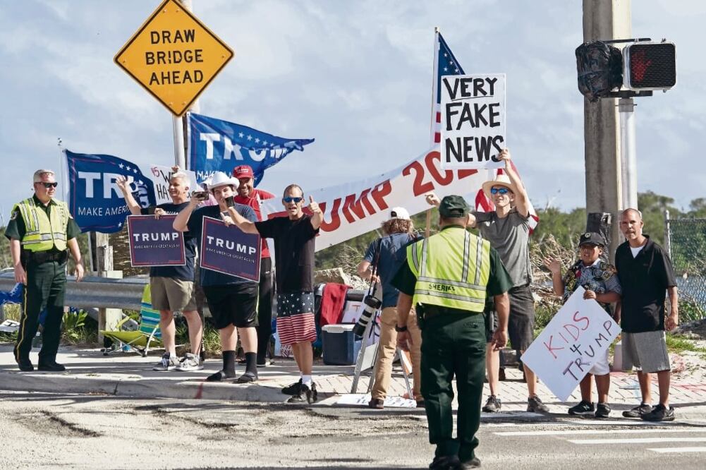 Simpatizantes del presidente Donald Trump esperaban ayer cerca de la mansión donde pasa las vacaciones de fin de año, en Mar-a-Lago, Florida. (NICHOLAS KAMM. AFP)