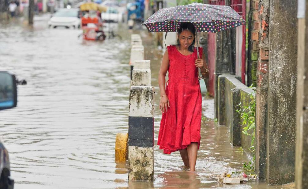 Una mujer camina por una calle inundada tras las fuertes lluvias monzónicas en Guwahati, el miércoles 13 de agosto de 2025. Foto: AP