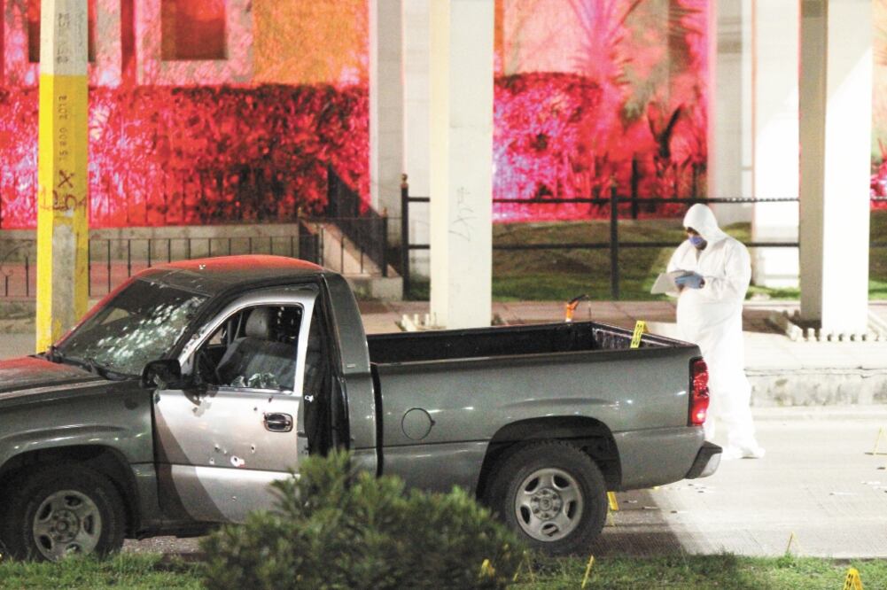 En el parabrisas de la camioneta oficial en la que viajaba el comandante del Grupo de Reacción quedaron los impactos de bala; al bulevar Morelos acudieron peritos en criminalística para investigar el crimen. (CUARTOSCURO)