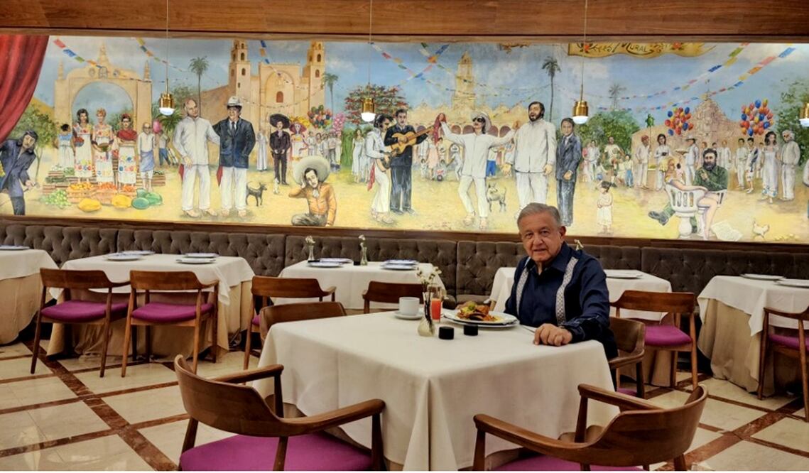 “Antes de iniciar la supervisión del Tren Maya, desayunando huevos motuleños y como fondo, el mural pintado por varios artistas dirigidos por el maestro Ariel Guzmán en enero de 1995, en un hotel en Mérida”, escribió López Obrador. Foto: @lopezobrador_