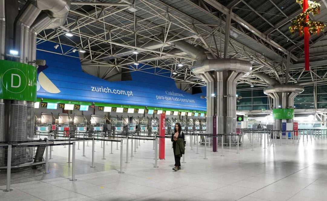 Una mujer camina por un hall casi desierto del aeropuerto de Lisboa al inicio de una huelga general para protestar contra una nueva reforma laboral anunciada por el gobierno de centroderecha, en Lisboa, el 11 de diciembre de 2025. Foto: AP