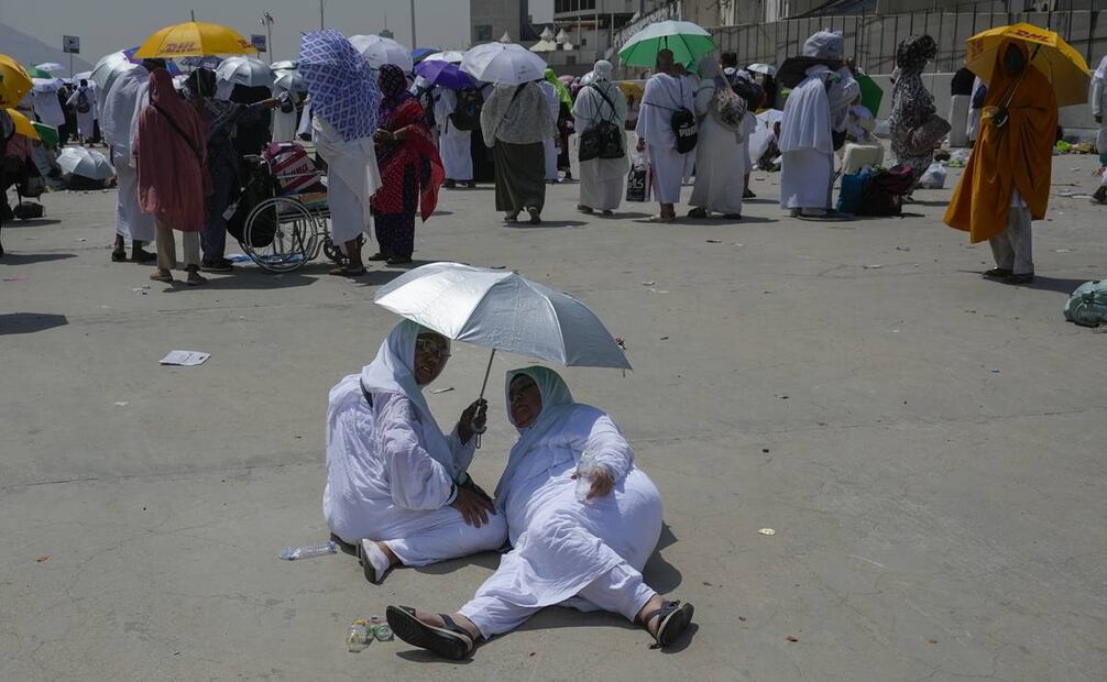 Dos peregrinas musulmanas se protegen del sol cerca de los pilares donde se realiza la lapidación simbólica del diablo, el último ritual del haj, en Mina, cerca de La Meca. Foto: AP