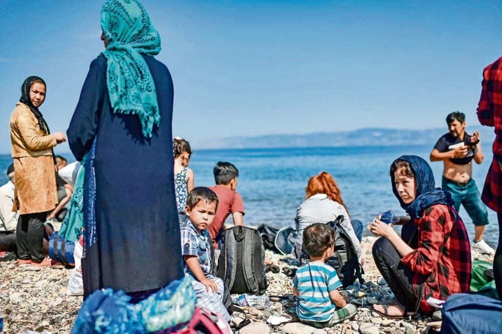 Migrantes de Afganistán llegaron ayer a la isla griega de Lesbos, después de cruzar el mar Egeo desde Turquía con un bote.(ARIS MESSINIS/AFP)