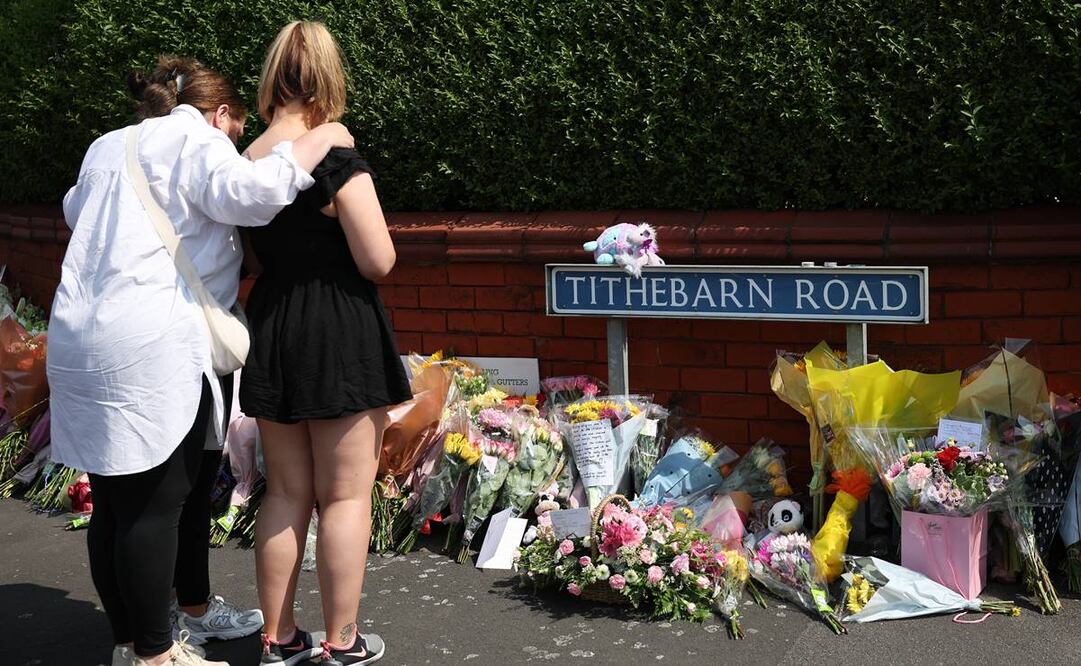 Gente mira los homenajes dejados en la escena de un ataque con puñaladas en el cruce con Hart Street en Southport, Gran Bretaña en una clase de baile con canciones de Taylor Swift. Foto: EFE