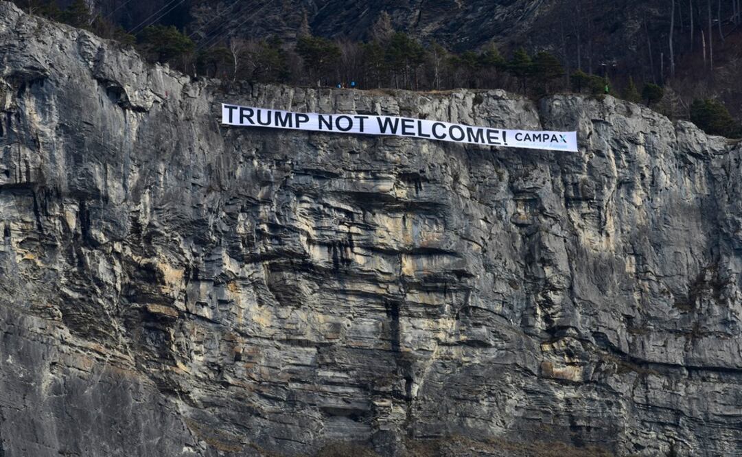 En esta foto difundida por la organización CAMPAX, un cartel con la inscripción en inglés "Trump no es bienvenido" pende de la ladera rocosa del monte Ellhorn cerca de Sargans (Foto: AP)