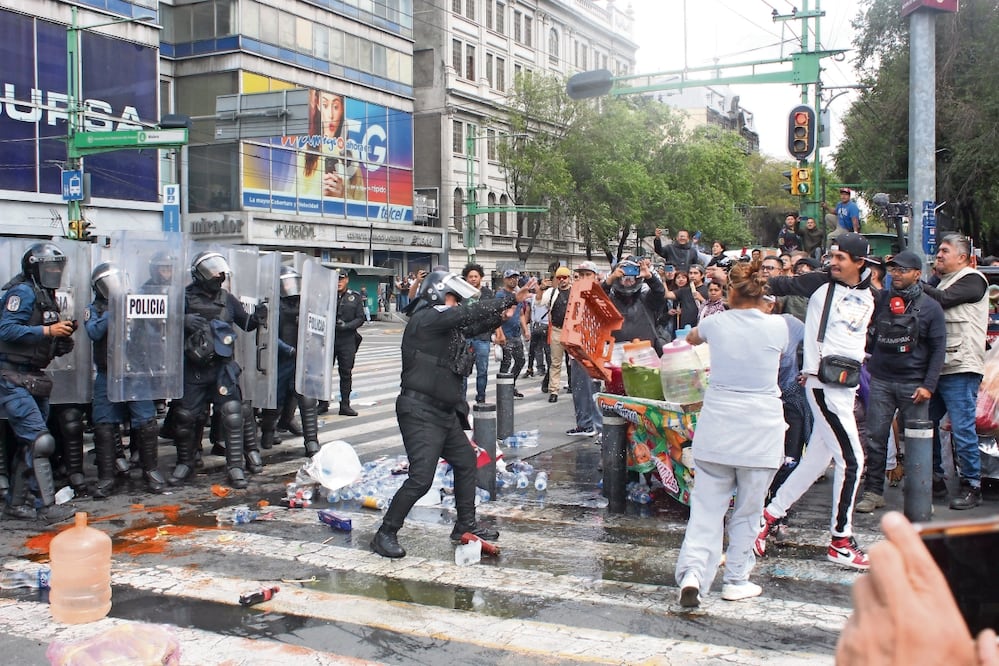 Comerciantes lanzaron botellas de agua, elotes y trozos de hielo a los policías. Foto: de Francisco Rodríguez. El Universal
