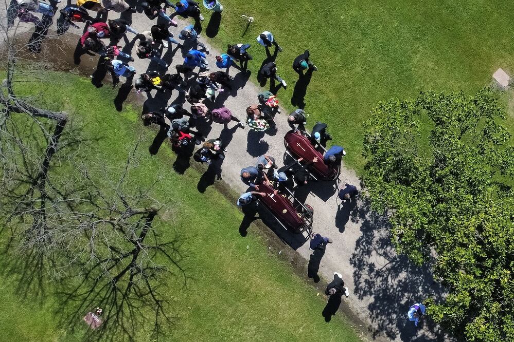 Fotografía aérea que muestra a los asistentes del funeral de Brenda del Castillo y Morena Verdi, víctimas de feminicidio, en el cementerio Las Praderas, en Buenos Aires. FOTO: ADAN GONZÁLEZ. EFE