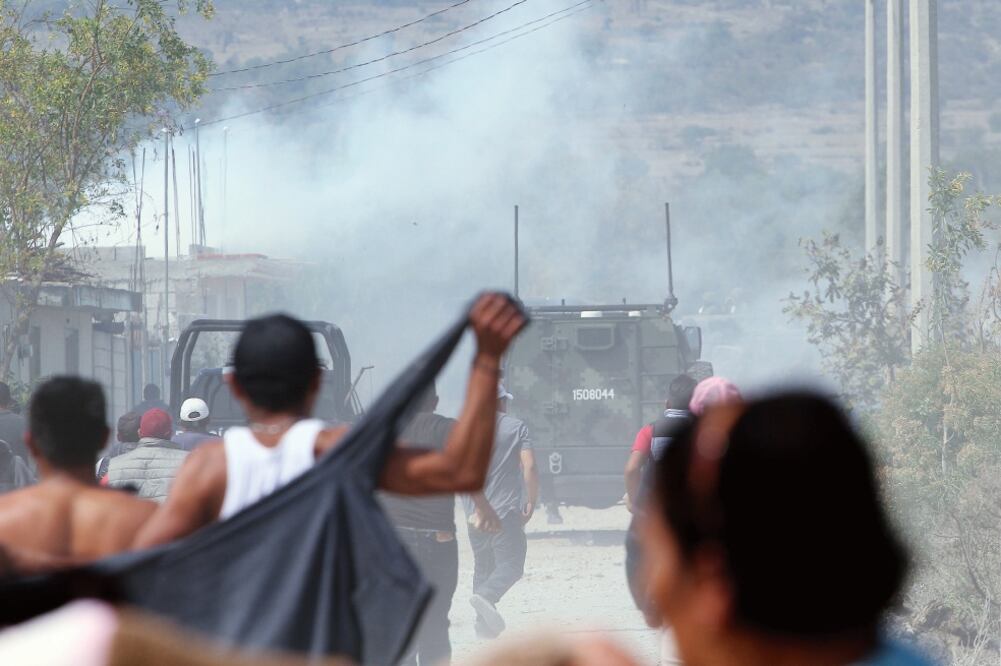 Vecinos de Palmarito trataron de contener el arribo de elementos del Ejército, tras el enfrentamiento la noche del miércoles entre militares y personas dedicadas al robo de combustible de ductos de la empresa Petróleos Mexicanos. (HILDA RÍOS. CUARTOSCURO)
