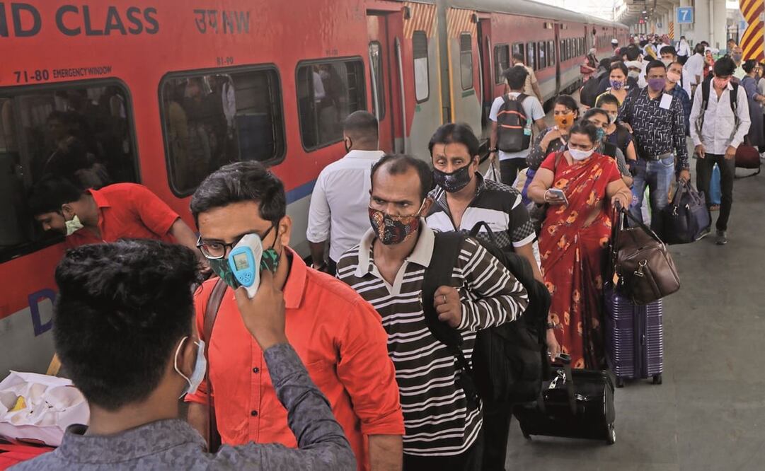Un empleado sanitario revisa la temperatura de un pasajero en una estación de tren en Bombay. Foto: Rajanish Kakade. AP