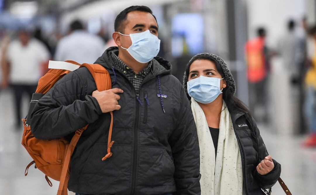 Passengers wear protective masks against the spread of coronavirus as they arrive at the Mexico City International Airport – Photo: Pedro Pardo/AFP