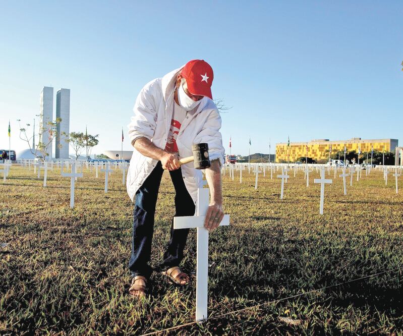 Varias personas instalaron ayer centenares de cruces como homenaje a las víctimas del Covid-19, en la Explanada de los Ministerios de Brasil. Foto: MYKE SENA. EFE