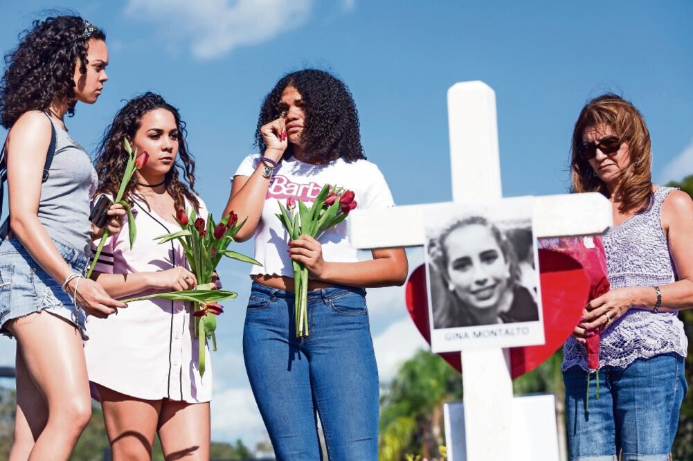 Estudiantes de la preparatoria Marjory Stoneman Douglas lloraron frente a las cruces que fueron colocadas en memoria de las víctimas del tiroteo. (MATIAS J. OCNER. AP)