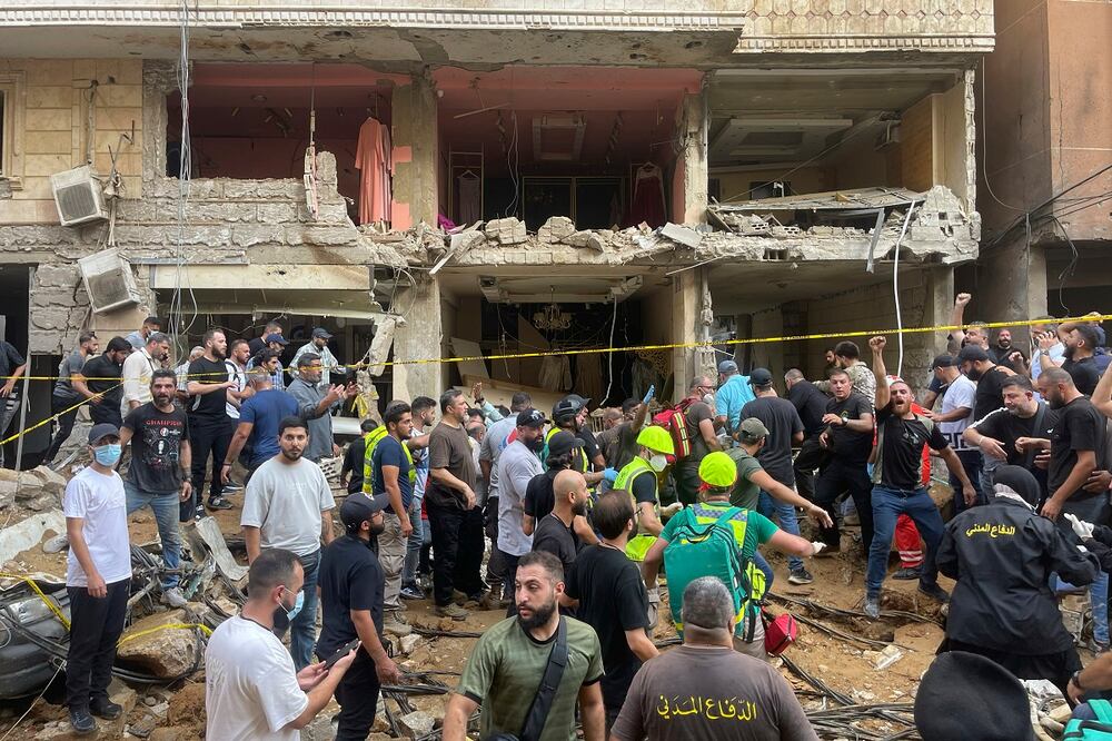 La gente se reúne cerca de un edificio dañado en el lugar de un ataque con misiles israelí en los suburbios del sur de Beirut. Foto: AP