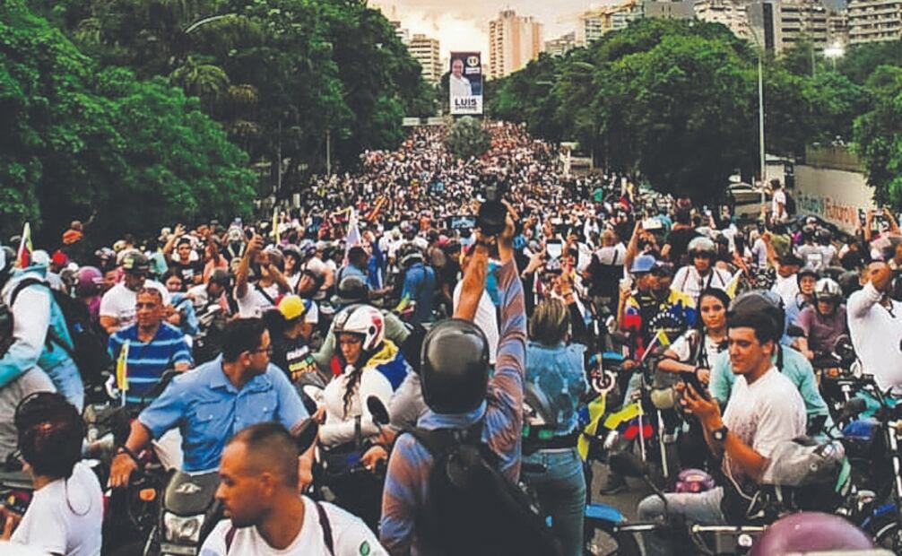 Un mar de esperanza: inicio de campaña de María Corina Machado en Caracas.
Miles de venezolanos colmaron las calles de Caracas el 4 de julio de 2024 para respaldar a María Corina Machado y a Edmundo González Urrutia como candidato único de la oposición, en el arranque oficial de su campaña presidencial. La multitudinaria concentración reflejó un claro mensaje de esperanza y determinación en medio del proceso electoral más esperado de los últimos años. Foto: de EZEQUIEL CARÍAS. EL NACIONAL
