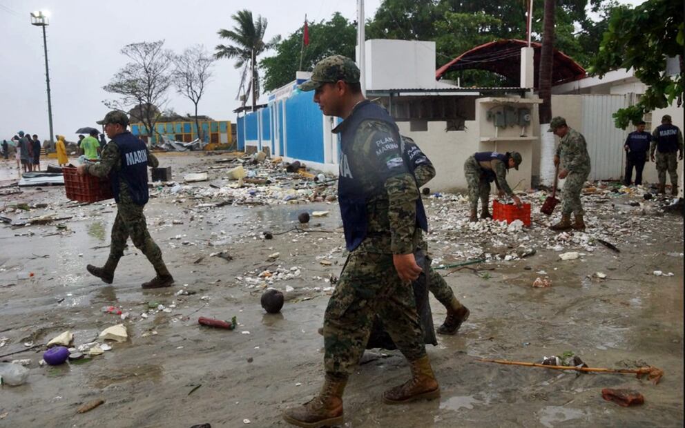 Elementos de la Marina ayudan a pescadores a sacar sus embarcaciones que quedaron enterradas bajo la arena y a retirar la basura que devolvió el mar en Puerto Escondido, tras el impacto de “Erick” en Oaxaca, el 19 de junio de 2025. Foto: Edwin Hernández/EL UNIVERSAL