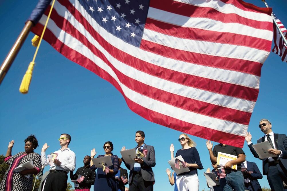 Un grupo de 35 migrantes tomaron ayer juramento durante una ceremonia de naturalización en Liberty State Park, en Nueva Jersey. (DREW ANGERER. AFP)