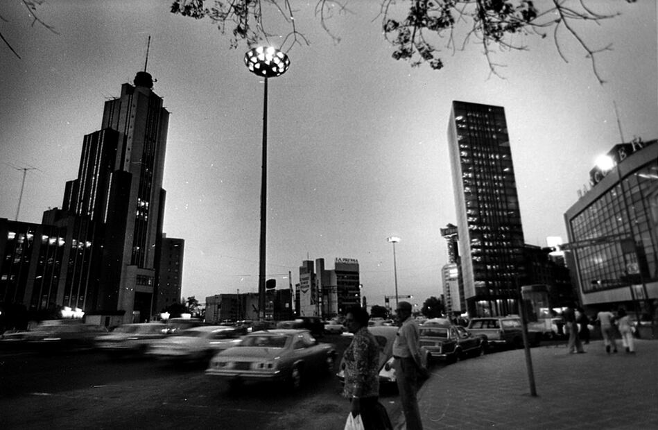 Una vista nocturna de los dos edificios de la Lotería Nacional, desde la esquina de la avenida Bucareli, a finales de 1979. Del lado izquierdo se encuentra el antiguo edificio de la Lotería Nacional, conocido como “El Moro”, cuando todavía tenía la antena en espiral en la parte superior; del derecho, la Torre Prisma, en la esquina del Paseo de la Reforma y la avenida Juárez. Imagen: Archivo EL UNIVERSAL.