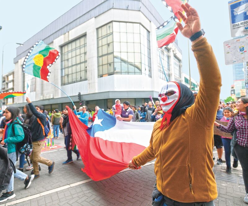 Manifestantes chilenos, algunos de ellos con máscaras y disfraces por ser el día del Halloween, marcharon ayer para exigir cambios sociales al gobieno de Sebastián Piñera. Foto: DIEGO IBACACHE. EFE
