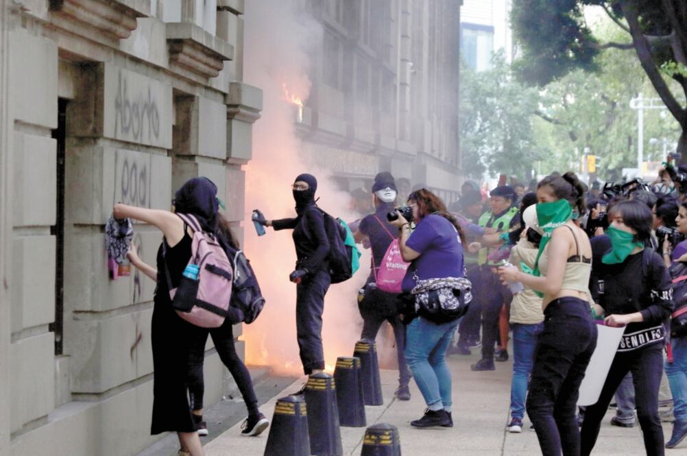 Las manifestantes prendieron fuego a las puertas de la Cámara de Comercio de la Ciudad de México (Canaco). Fotos/CARLOS MEJÍA. EL UNIVERSAL