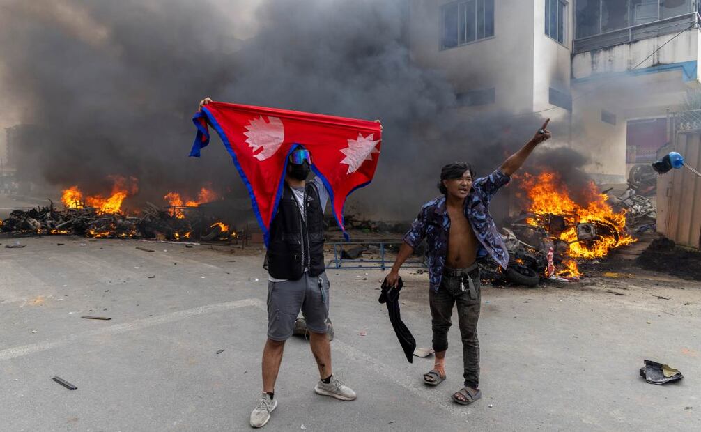 Manifestantes frente a la oficina del Partido Comunista de Nepal - Marxista-Leninista Unificado (CPN-UML) que fue incendiada en Katmandú, Nepal, el 9 de septiembre de 2025, un día después de que al menos 19 personas murieran y docenas resultaran heridas durante las manifestaciones contra la corrupción y la prohibición gubernamental de las redes sociales. Foto: EFE