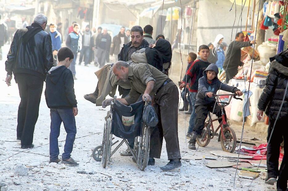 Sirios ayudan a una mujer en al-Sukkari, Aleppo, tras un bombardeo de fuerzas leales a Bashar al-Assad, el sábado, según activistas (REUTERS)