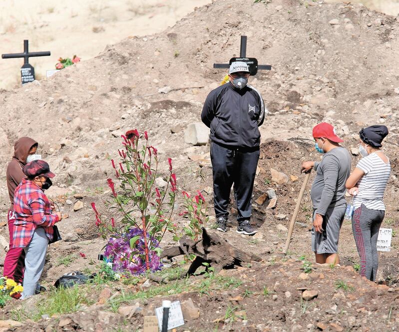 Familiares visitan las tumbas de sus seres queridos en el parque Memorial Jardín de los Ángeles, Honduras, cementerio dispuesto para muertos por Covid.  Gustavo Amador. EFE