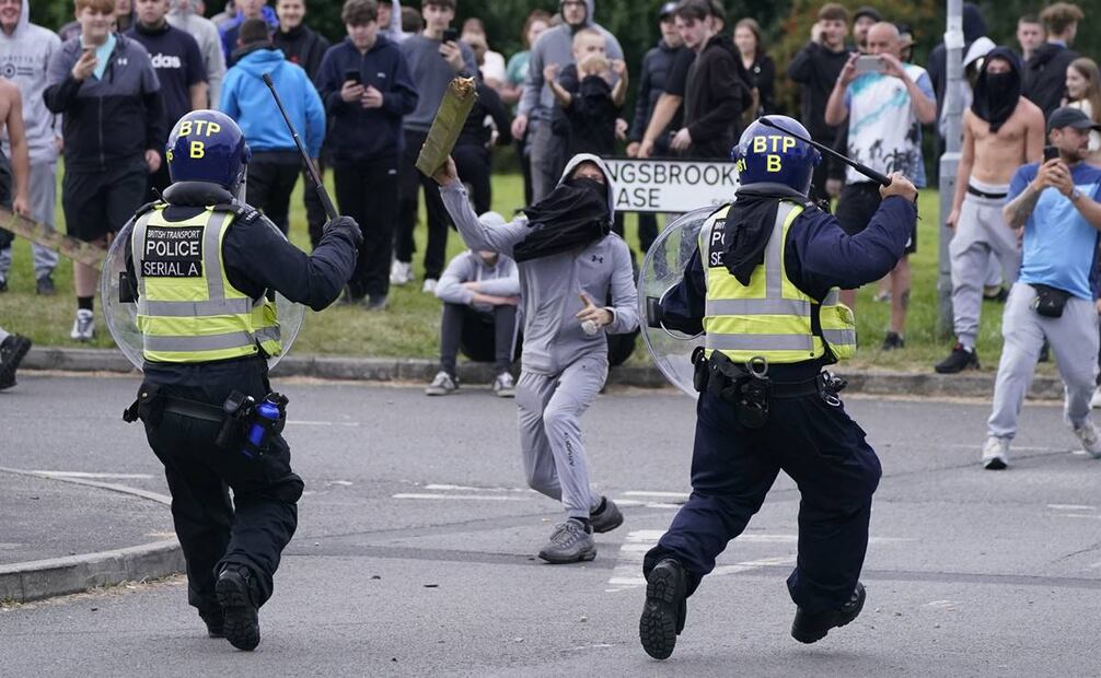Un joven arroja un poste hacia la policía durante una manifestación contra la inmigración. Foto: AP