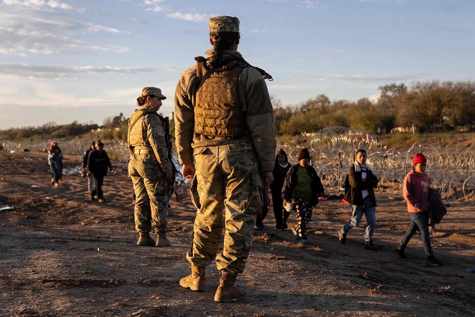 Soldados de la Guardia Nacional de Texas observan a miles de migrantes dirigirse a un centro de tránsito en Eagle Pass, Texas. FOTO: JOHN MOORE. AFP