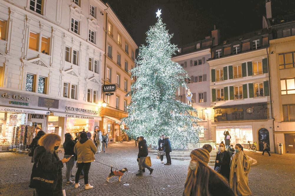 Personas en Lausana, Suiza. Por la pandemia, las autoridades cancelaron la mayoría de las tradiciones festivas, como mercados navideños o las campanadas de fin de año. Foto: FABRICE COFFRINI. AFP
