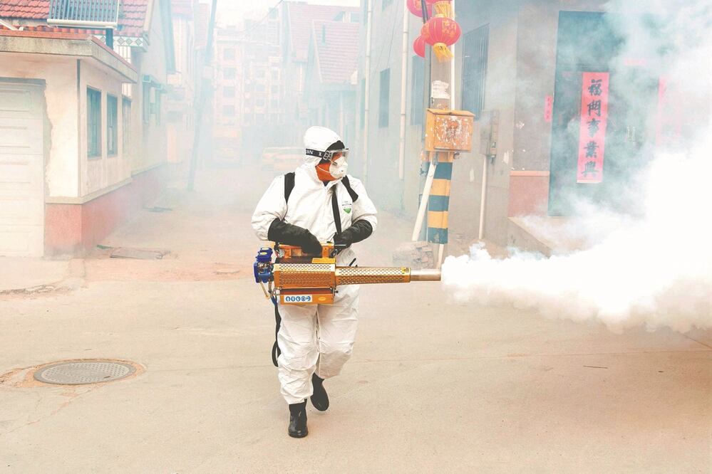 Un trabajador en traje de protección desinfecta la aldea Dongxinzhuang, en China. Foto: Reuters