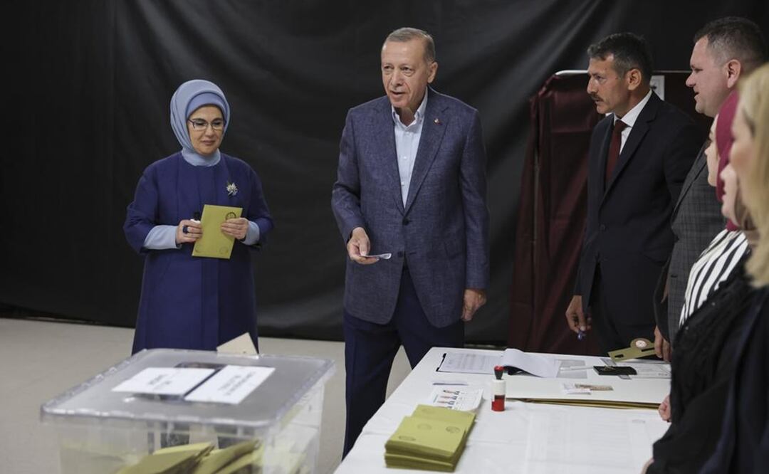 El presidente turco, Recep Tayyip Erdogan, al centro, y su esposa Emine, se preparan para emitir su voto en un colegio electoral en Estambul. Foto: AP