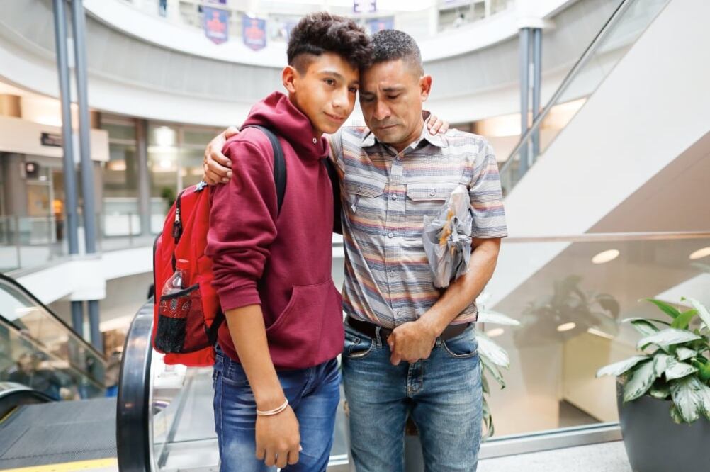 Un guatemalteco abraza a su hijo en el Aeropuerto Internacional de Kentucky, donde se reunieron tras haber sido separados por las autoridades migratorias hace un mes. (JOHN MINCHILLO. AP)