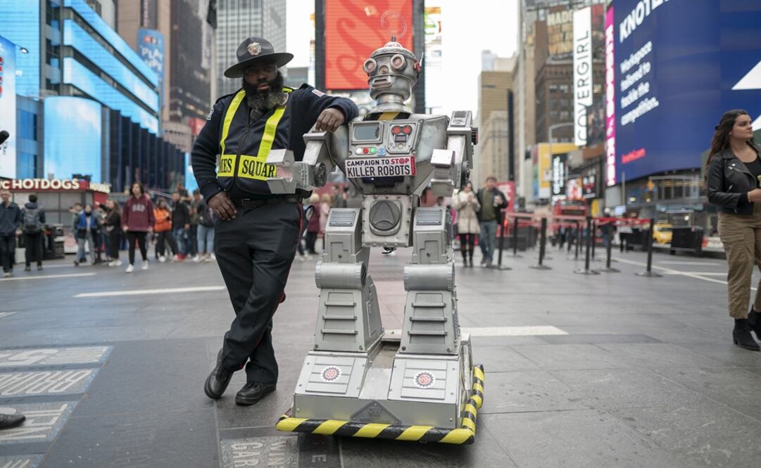 Un agente de seguridad  posa junto a un robot el 20 de octubre en Times Square, Nueva York. Foto: /Campaign to Stop Killer Robots