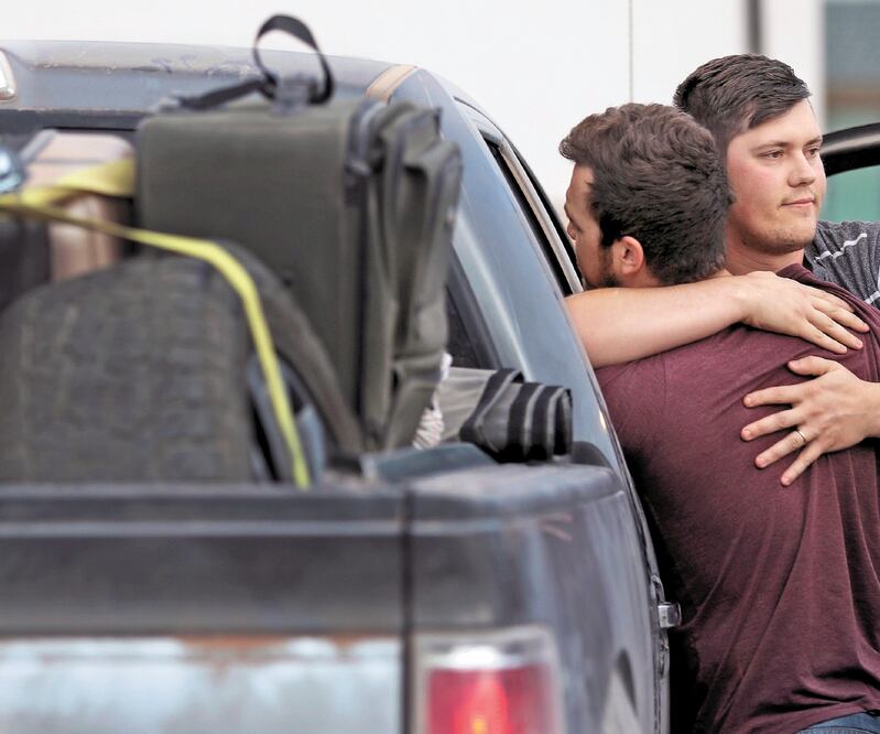 Integrantes de la comunidad mormona que decidieron retornar a Estados Unidos tras el asesinato de nueve de sus familiares se abrazan en una gasolinera en Douglas, donde cargan combustible para seguir su camino rumbo a Tucson y Phoenix. KELLY PRESNELL. AP 