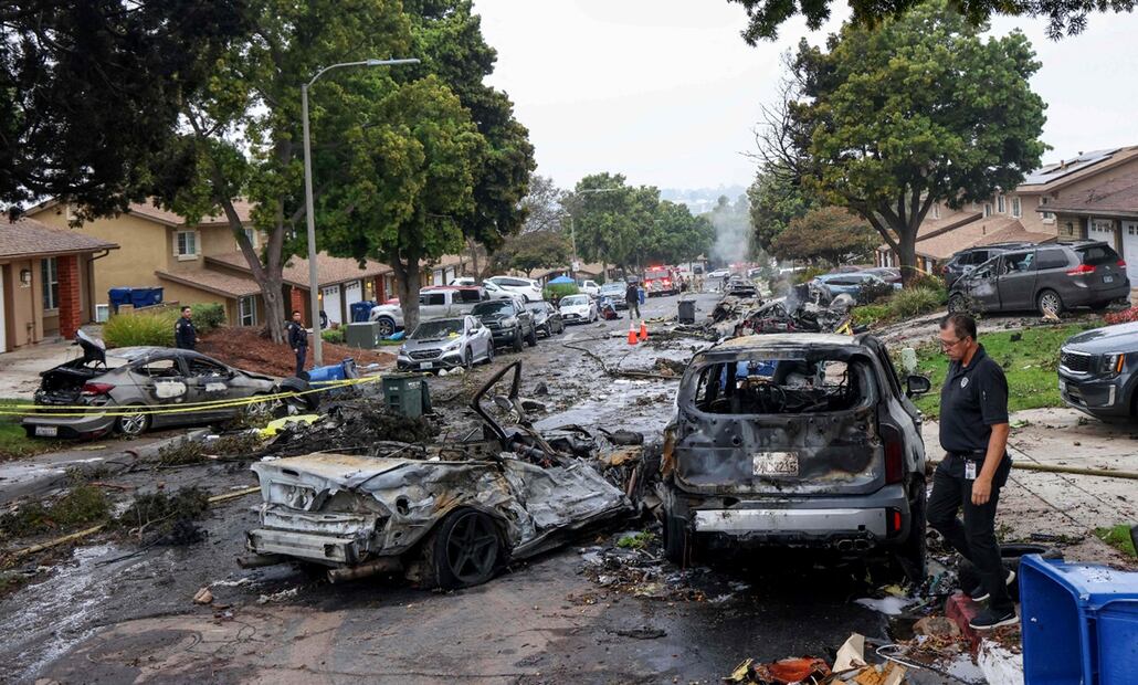 Investigadores inspeccionan el lugar donde una avioneta se estrelló en una calle residencial de San Diego, California, el 22 de mayo de 2025. Foto: AFP