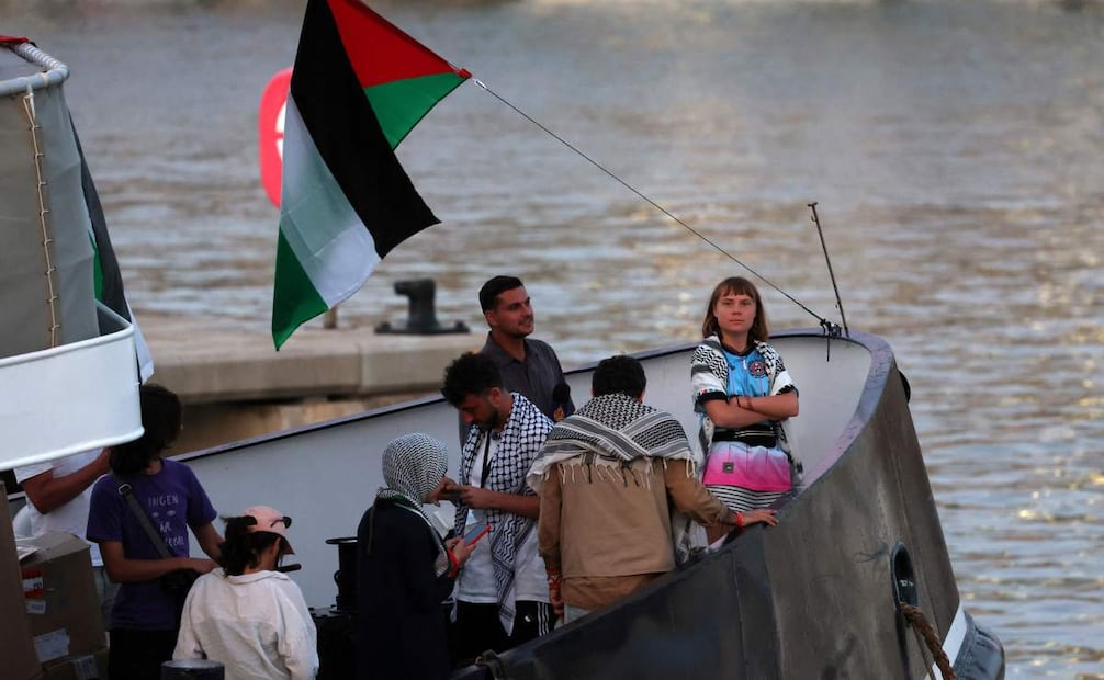 La activista climática sueca Greta Thunberg (derecha) aparece a bordo de un buque de una flotilla civil que transporta activistas pro-palestinos y ayuda humanitaria, con el objetivo de romper el bloqueo israelí de la Franja de Gaza. Permanece amarrada en el puerto de Barcelona el 1 de septiembre de 2025, tras verse obligada a regresar debido al mal tiempo. España enviará un buque de la Armada para apoyar a la flotilla de ayuda a Gaza, según informa AFP el 24 de septiembre de 2025. Foto: AFP