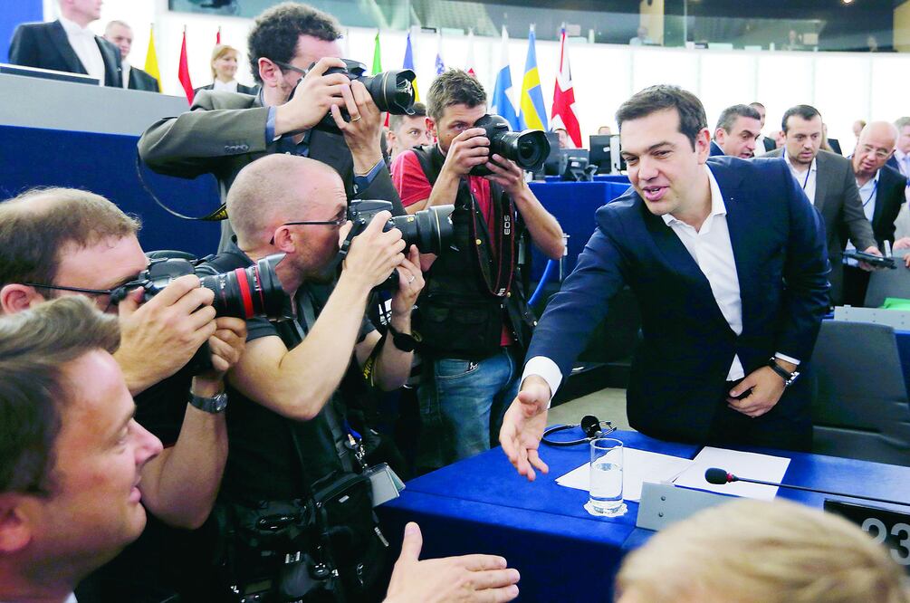El primer ministro de Grecia, Alexis Tsipras, saluda a un miembro del Parlamento Europeo, en Estrasburgo, ayer, antes de pronunciar un mensaje ante el organismo, donde algunos sectores de la izquierda le aplaudieron (VINCENT KESSLER / REUTERS)