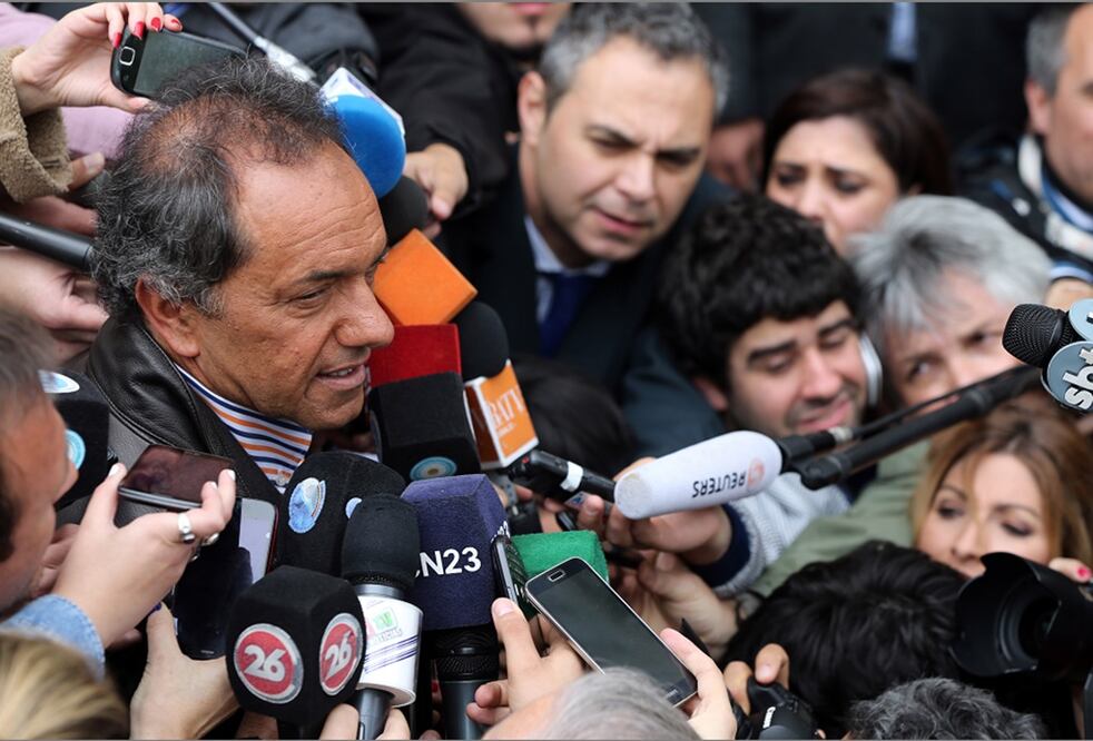 El candidato presidencial oficialista Daniel Scioli habla con la prensa luego de votar en la localidad de Tigre (AP)