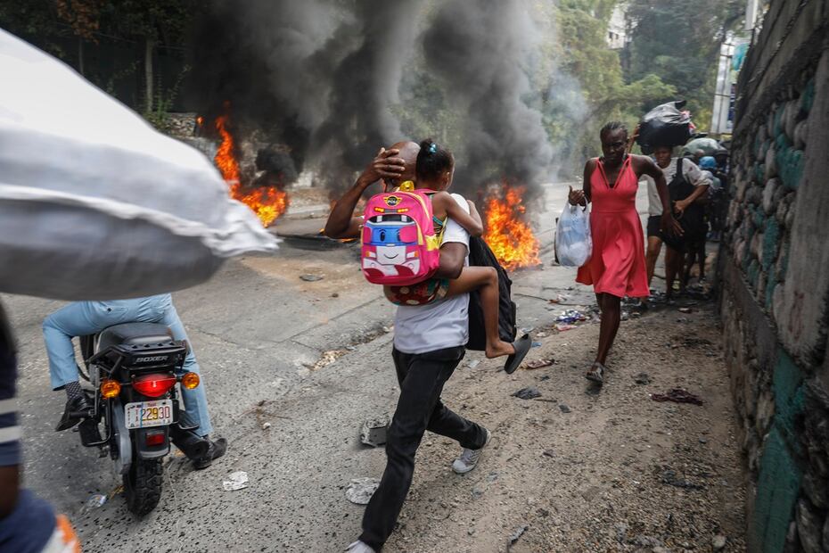 La gente pasa junto a neumáticos quemados durante una protesta contra el primer ministro haitiano, Ariel Henry, en Puerto Príncipe, Haití. Foto: AP