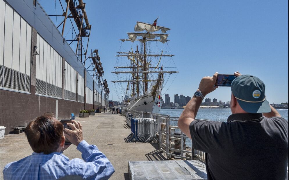 Un par de personas toman fotografías del Buque Cuauhtémoc estacionado en el puerto 36, en Nueva York. Foto: EFE